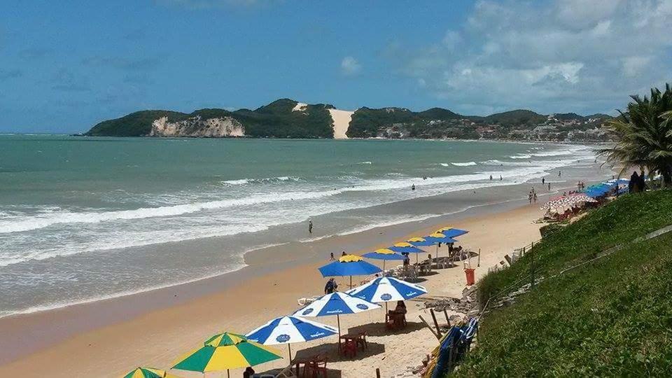 a beach with umbrellas and chairs and the ocean at Araça Flat Natal Prime - Beira Mar in Natal