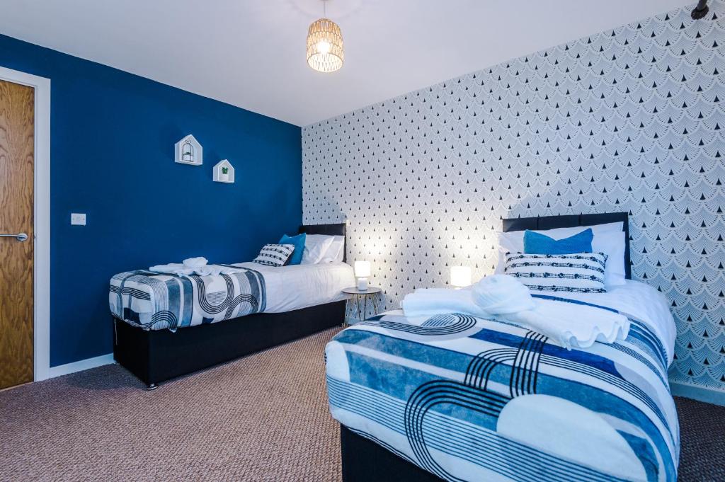 2 Betten in einem Zimmer mit blauen Wänden in der Unterkunft Lovely 2-bed apartment *free parking *pool table in Liverpool