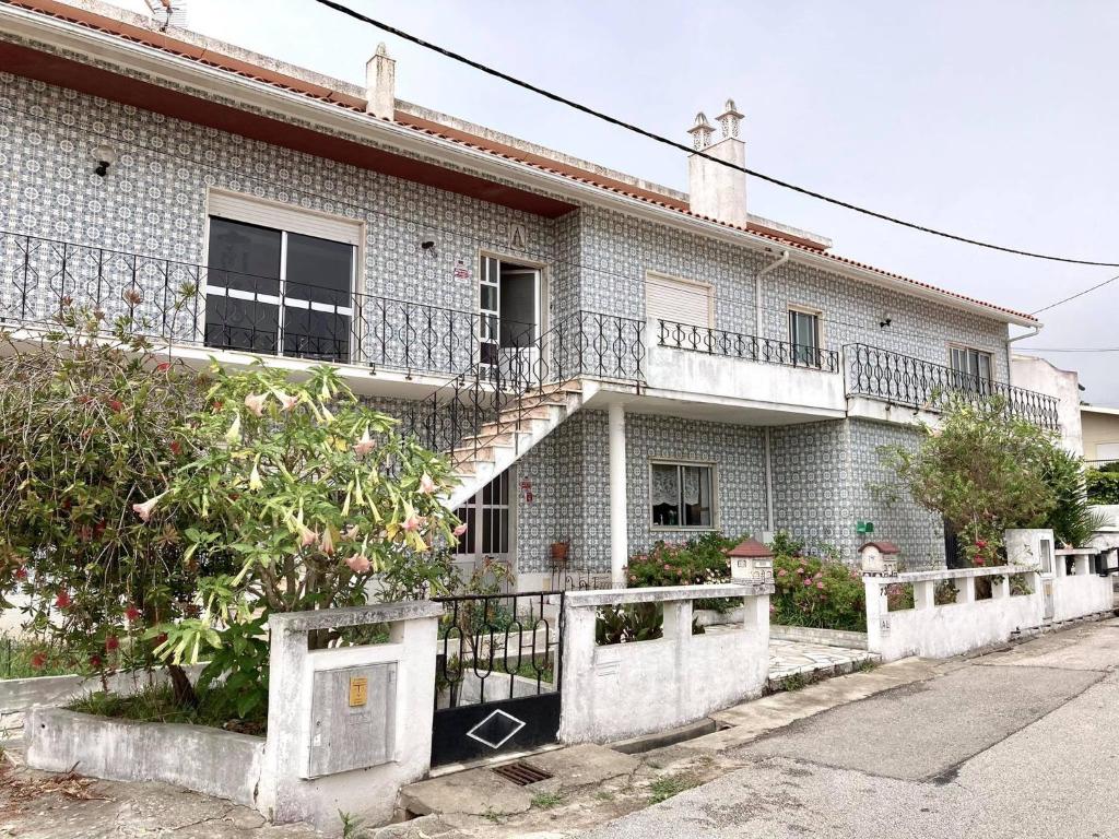 an old white brick house with a staircase at Casinha do mar in Buarcos