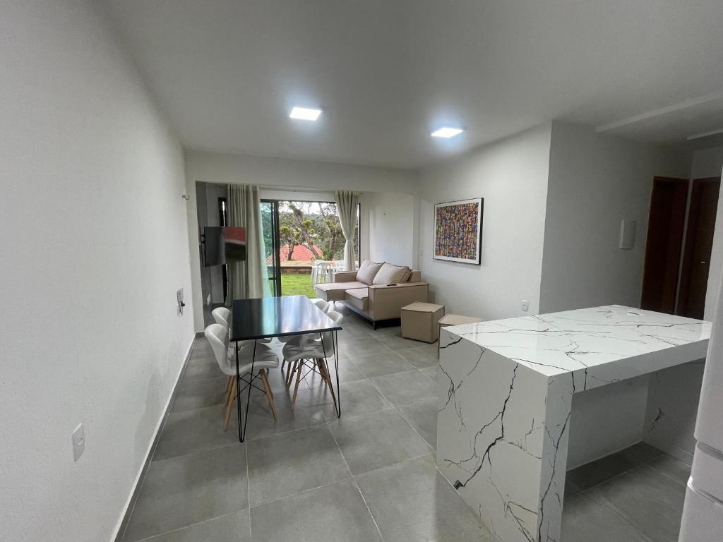 a kitchen and living room with a table and a couch at Casa em Condomínio Montserrat in Guaramiranga