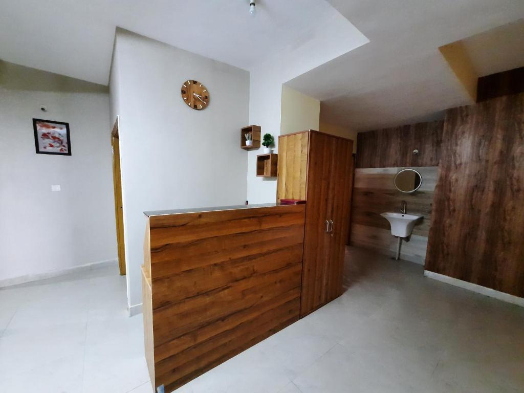 uma casa de banho com uma porta de madeira e um lavatório em The Candy Heights em Ranchi