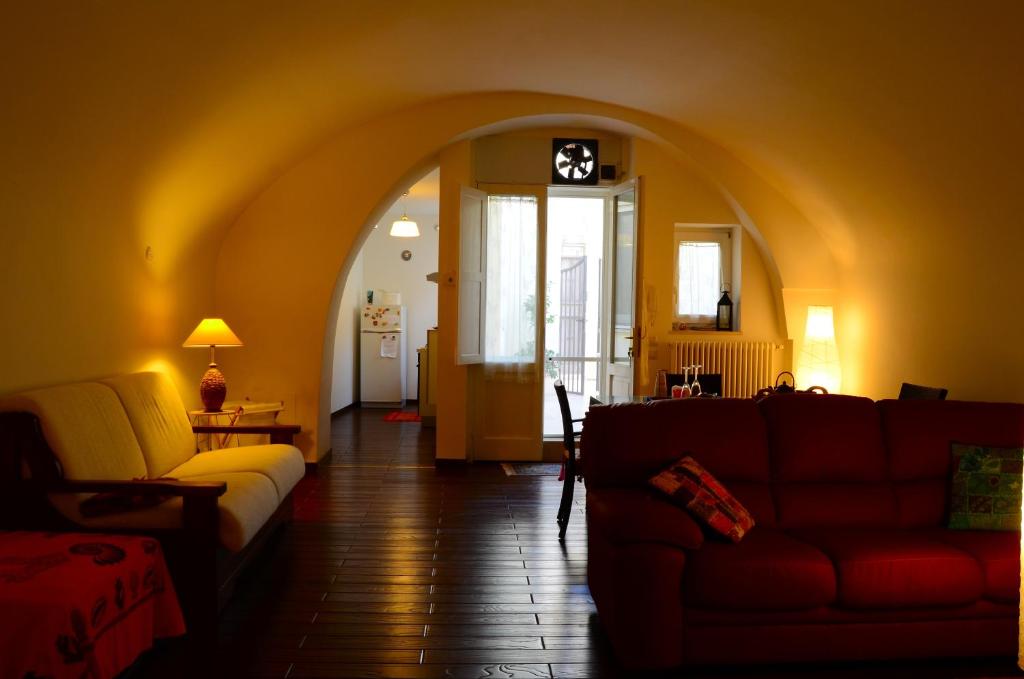 uma sala de estar com um sofá e uma sala com um arco em La Dimora di Cesare Affittacamere em Matera