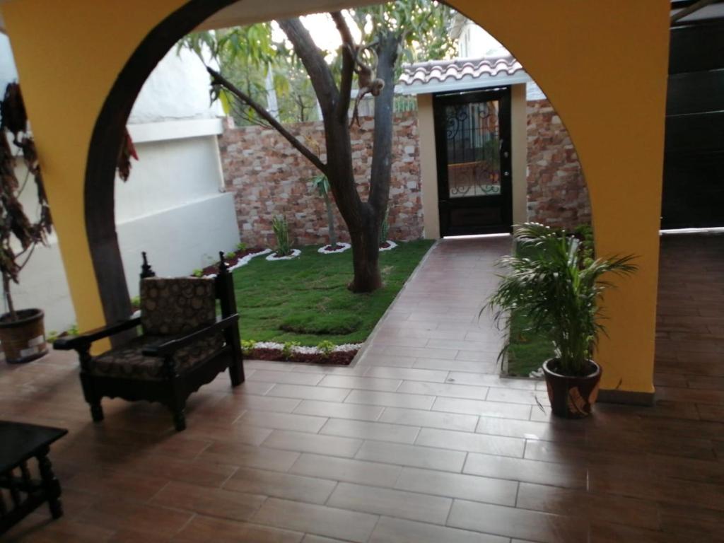 einen Innenhof mit einem Torbogen mit einer Bank und einem Baum in der Unterkunft Casa Mango in Ciudad Valles