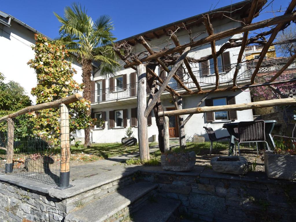 eine Pergola vor einem Haus mit einer Palme in der Unterkunft Attractive Holiday Home in Trarego Viggiona with Garden in Trarego Viggiona