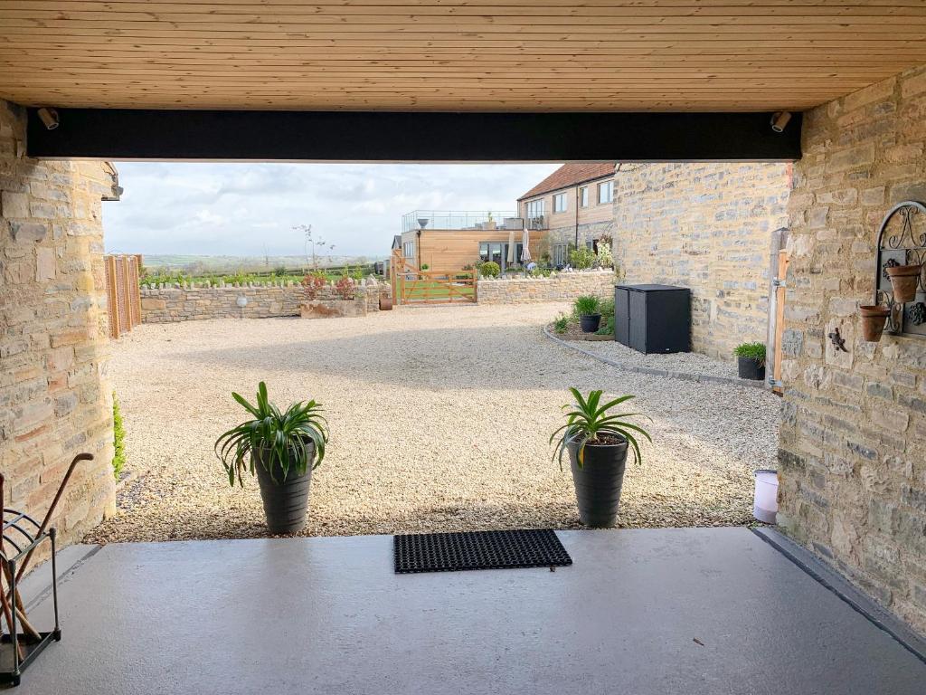 a patio with two potted plants in a building at Olive Tree Cottage in Langport