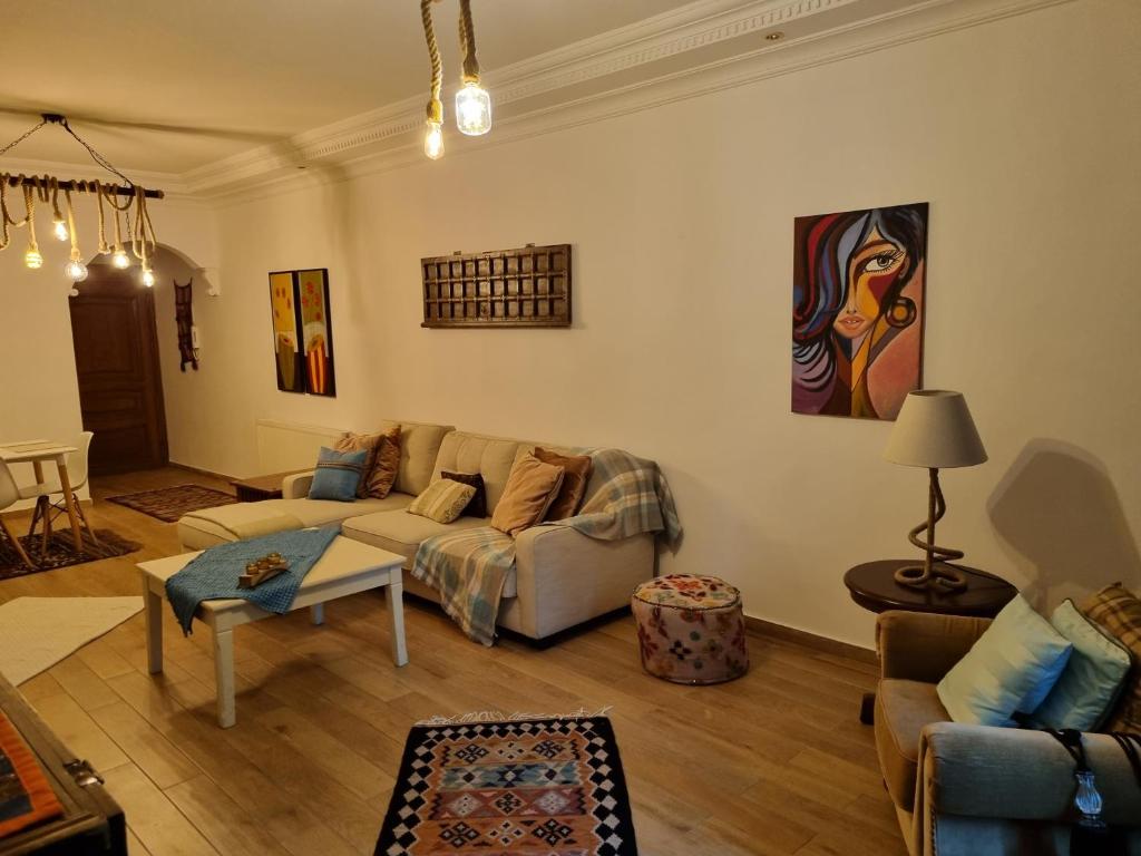 a living room with a couch and a table at Su's AlKursi Cozy Apartment in Amman