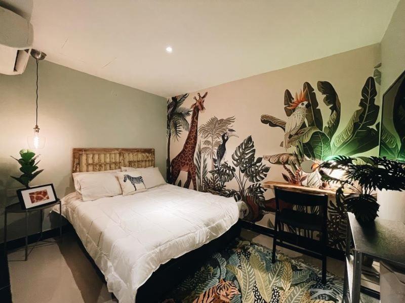 a bedroom with a bed with a mural of a giraffe at Very Hotel in George Town