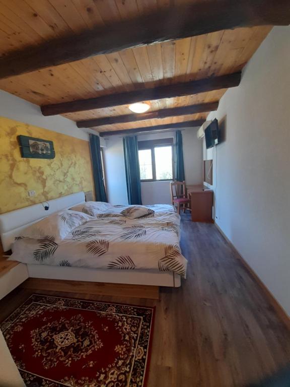 1 dormitorio con cama y techo de madera en Bed and Breakfast Lovac, en Kaldanija