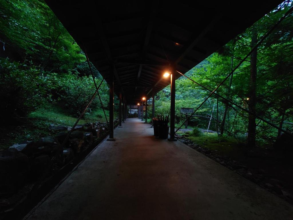 a covered walkway in a forest at night at Hoeiso in Hakone