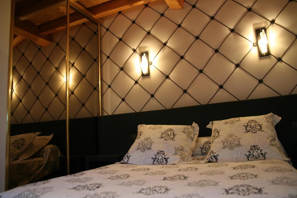 een slaapkamer met een bed met 2 kussens en 2 verlichting bij Les Ecuries de la Tour in Mondonville
