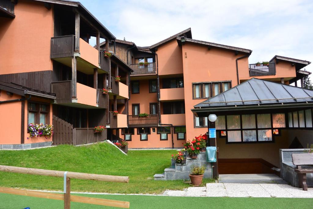 a large apartment building with a lawn in front of it at Multiproprietà Rio Falzè in Madonna di Campiglio