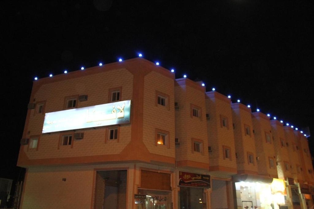 un bâtiment avec des lumières au-dessus de celui-ci la nuit dans l'établissement Lavina Hotel Apartments, à Sakaka