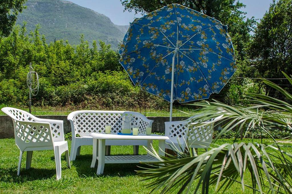 Holiday Home Oaza في كانج: طاولة وكرسيين ومظلة زرقاء