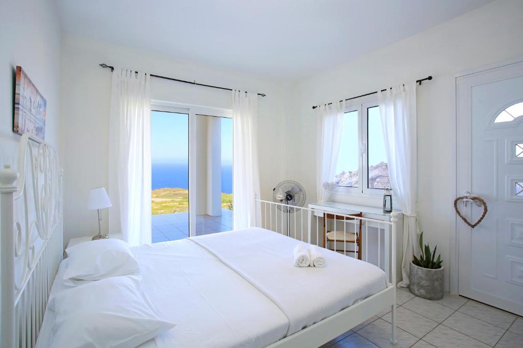 - une chambre blanche avec un lit et une vue sur l'océan dans l'établissement Villa Alice - Cretan Home Experience with Sea View, à Agia Pelagia