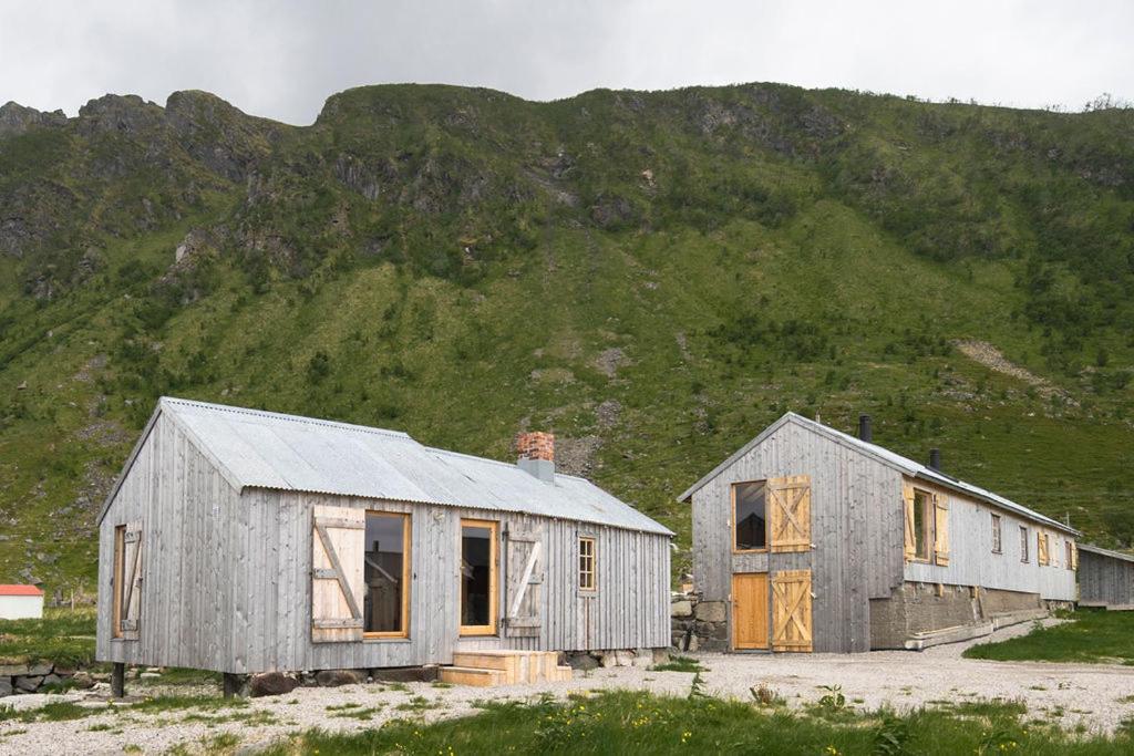 an old barn and a house in front of a mountain at The Steamery in Kvalnes