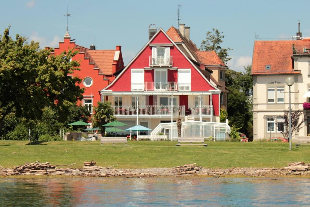 ein großes rotweißes Haus neben dem Wasser in der Unterkunft Gästehaus Seeblick in Langenargen
