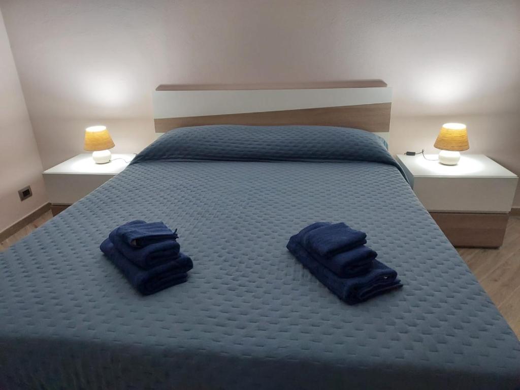 dos toallas azules sentadas en una cama con dos lámparas en Welcome to "La vista dei sogni", en Montauro