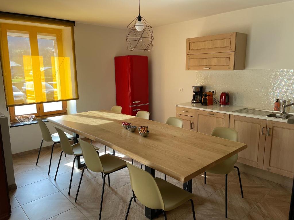 a kitchen with a wooden table and a red refrigerator at la vie en rose in Muno