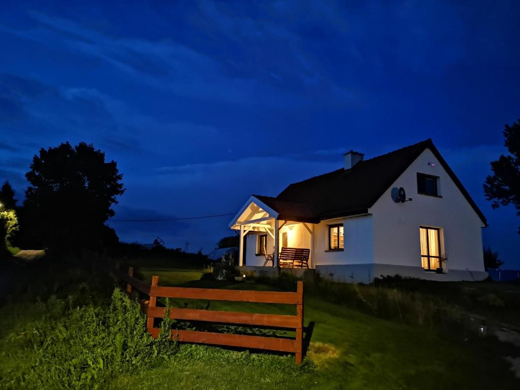 Una casa blanca en una colina por la noche en Siedlisko Orzechówko en Orzechówko