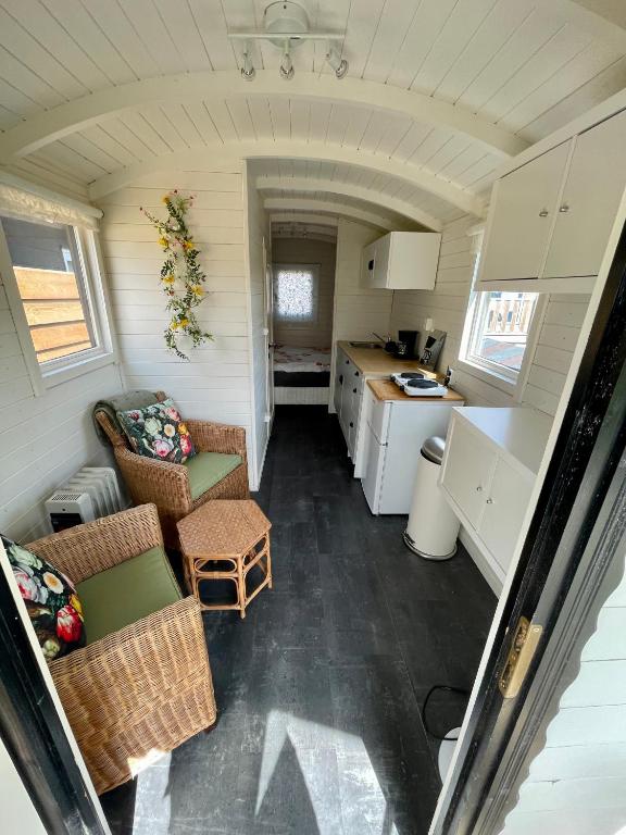 a small kitchen and living room in a tiny house at Pipowagen aan zee in Bergen aan Zee