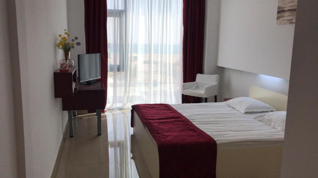 Hotel Hefaistos - Mamaia في مامايا: غرفه فندقيه سرير وتلفزيون