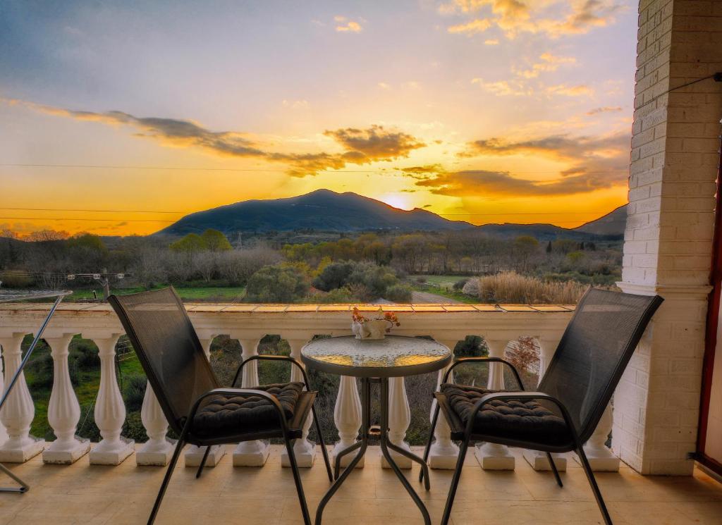 a patio with a table and chairs with a view of a mountain at Katerina's Sunset Apartment in Episkopianá
