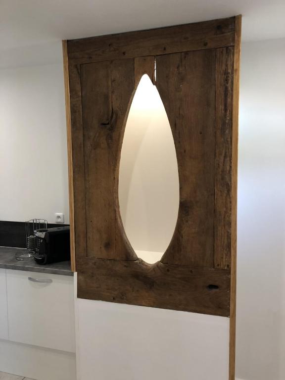 a mirror with a wooden frame on top of a counter at Les Vieille tuiles in Cudos