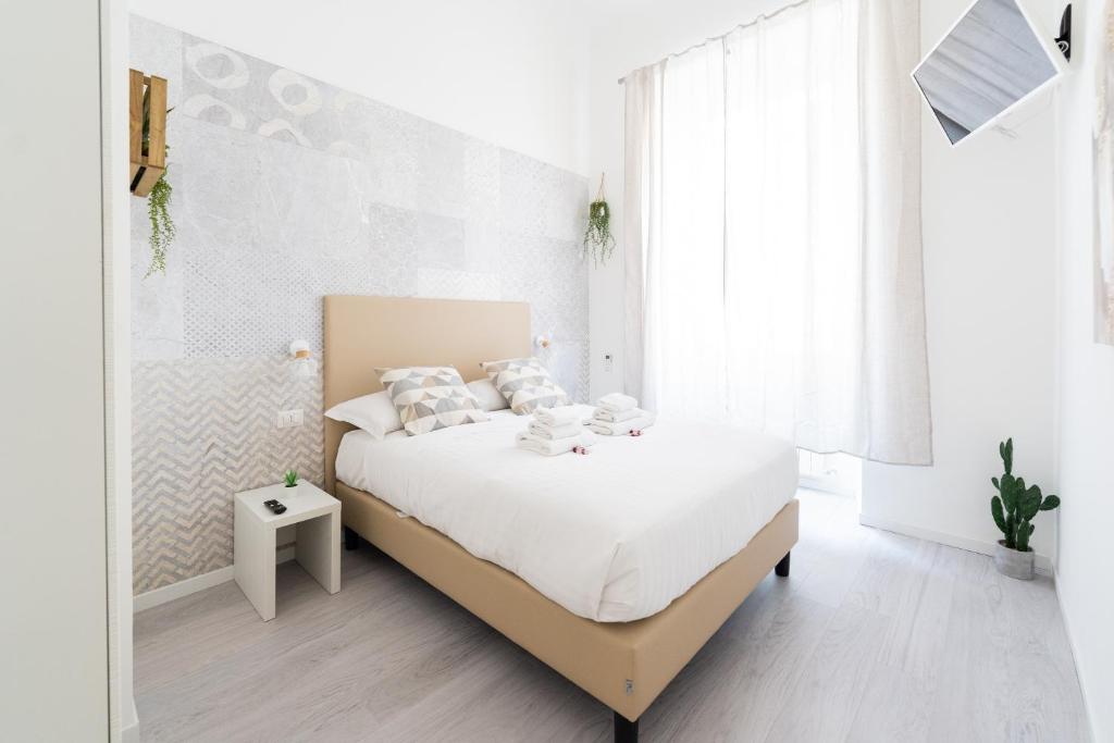 a bedroom with a bed with white sheets and pillows at White Gioberti Apartments in Rome