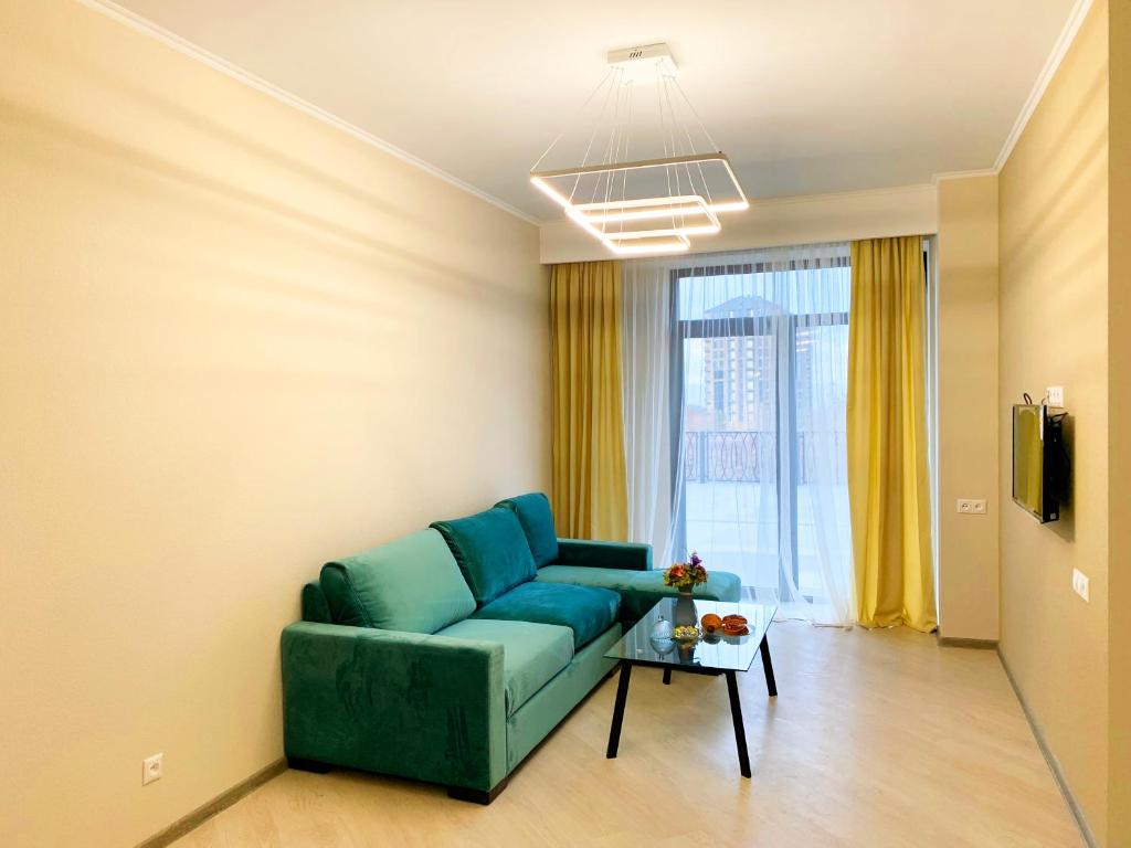 sala de estar con sofá azul y mesa en Uparthotel en Tsaghkadzor