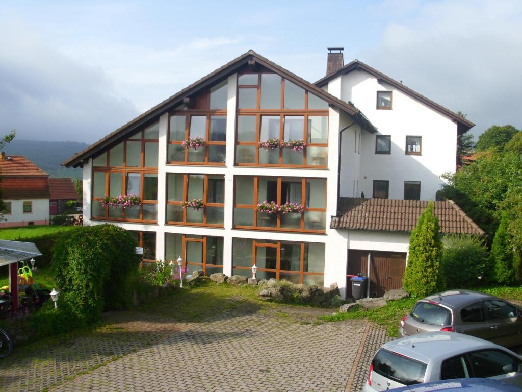 a white house with windows and cars parked in front at Pension Dreiländereck in Birx