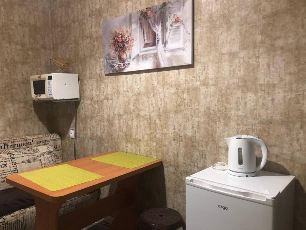 eine Küche mit einem Tisch und einem kleinen Kühlschrank in der Unterkunft 1 ком квартира с газом вблизи ЖД вокзала in Odessa