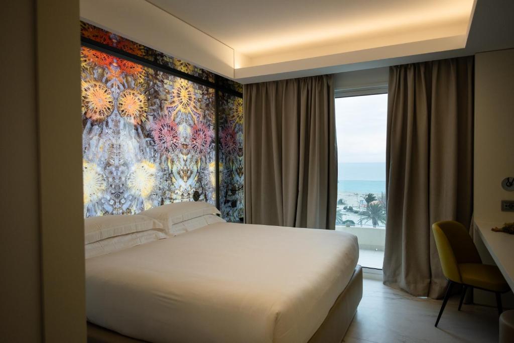 sypialnia z łóżkiem i dużym oknem w obiekcie Ghibli Hotel w mieście Civitanova Marche