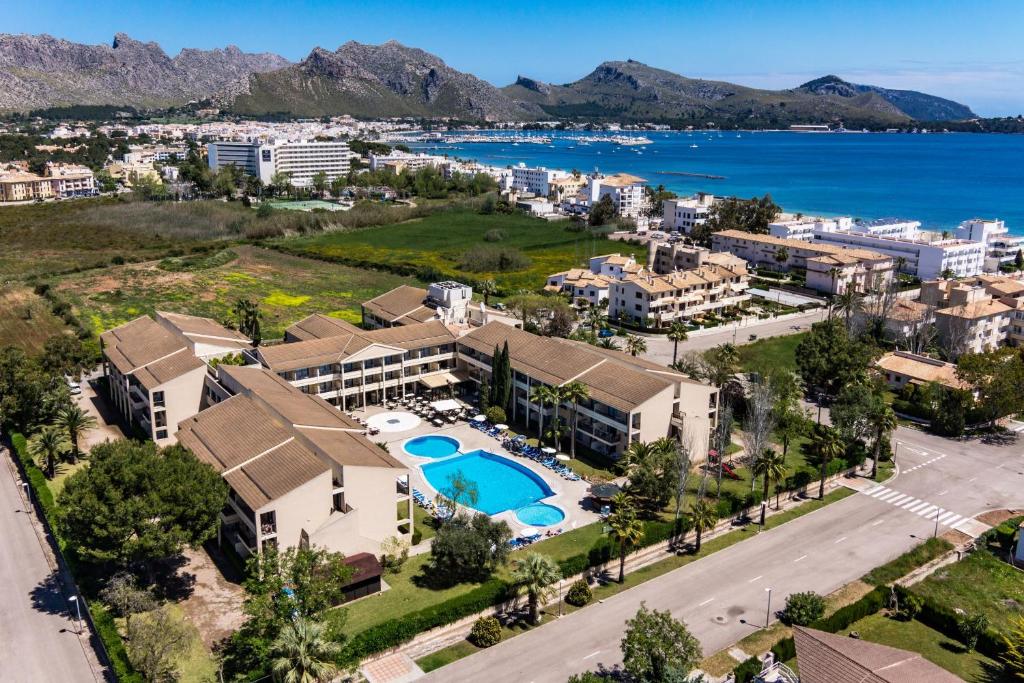 einem Luftblick auf ein Resort mit Pool und Meer in der Unterkunft Aparthotel Bahia Pollensa in Port de Pollença