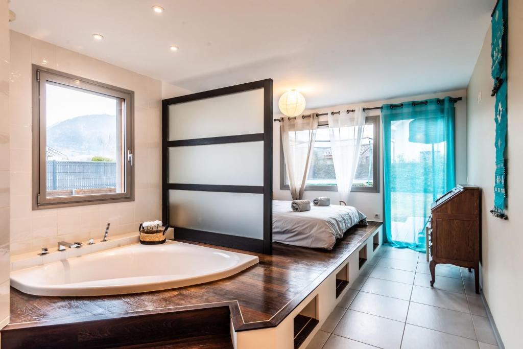 baño con bañera y cama de fondo en Villa tout confort - Piscine - Montagnes - Lac - Parking, en Armoy