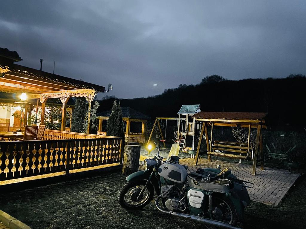 ein Motorrad, das vor einem Haus geparkt ist in der Unterkunft Agropensiunea Valea Fagilor in Luncaviţa