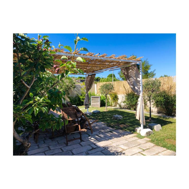 a wooden pergola with a bench and a table at Bio&amp;B Acquaviva in Otranto