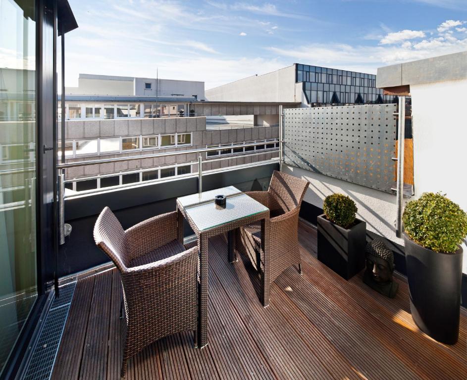 een balkon met een tafel en stoelen in een gebouw bij GuestHouse Mannheim in Mannheim