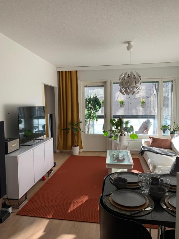 uma sala de estar com um sofá e uma televisão em Holiday Home Turku City em Turku