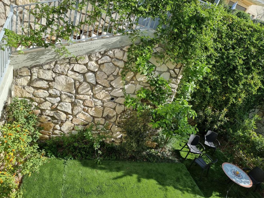 einen Blick über einen Garten mit einer Steinmauer in der Unterkunft Kiryat Tivon, Close by - Oranim College + parking in Oranim