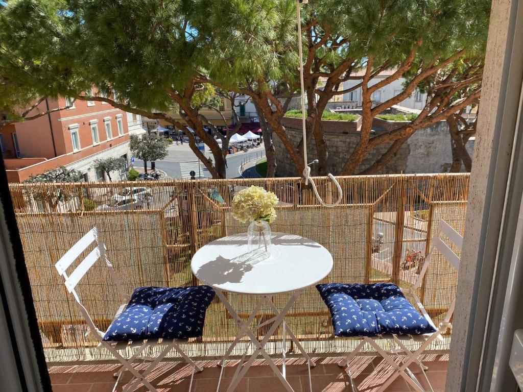 einen Tisch mit 2 Stühlen und eine Vase Blumen auf dem Balkon in der Unterkunft La Casa di Bea in Piombino