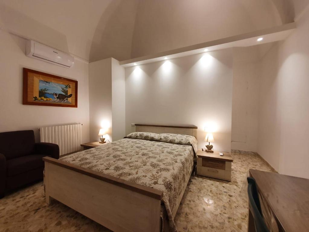- une chambre avec un lit, un canapé et deux lampes dans l'établissement Stella Maris, à Conversano