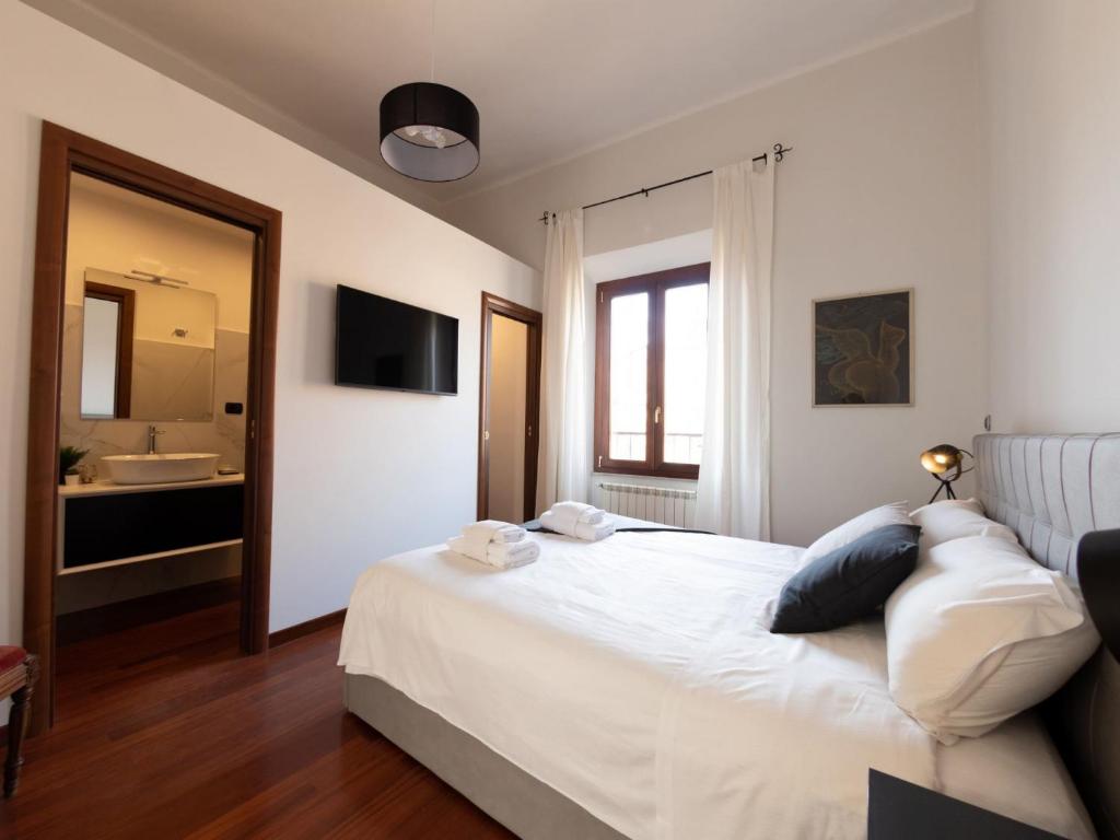 sypialnia z białym łóżkiem i łazienką w obiekcie The Best Rent - Apartment with a view on Altare della Patria w Rzymie