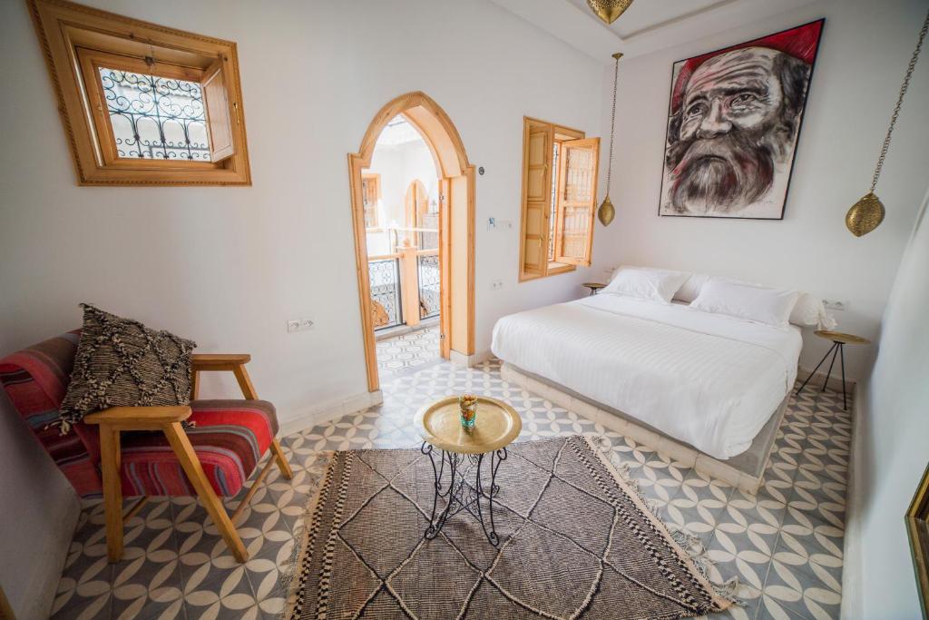 um quarto com uma cama, uma mesa e uma cadeira em Riad Le Petit Joyau em Marrakech