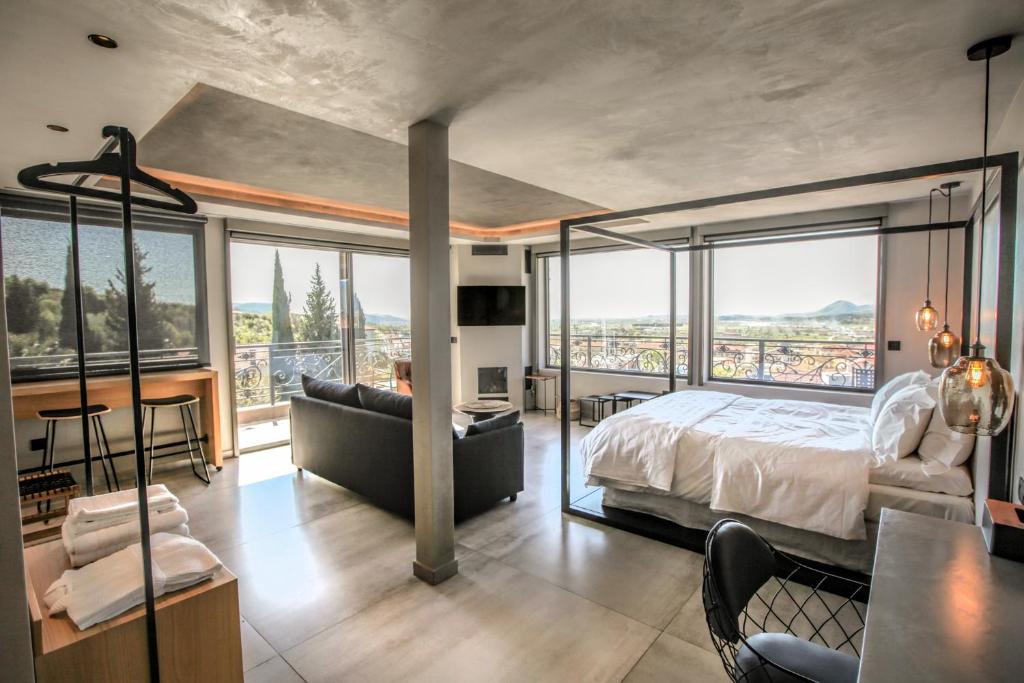 ein Hauptschlafzimmer mit einem Bett und einem Balkon in der Unterkunft Meteora Heaven and Earth premium suites - Adults Friendly in Kalambaka