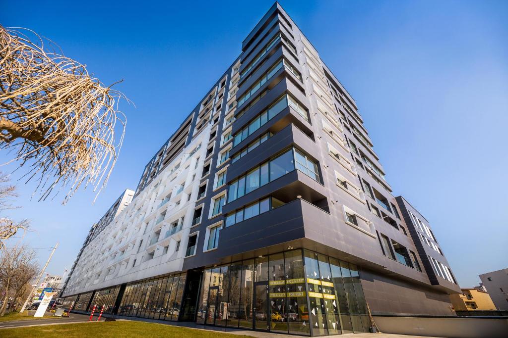a tall black building with glass windows at The Address Bucharest in Bucharest