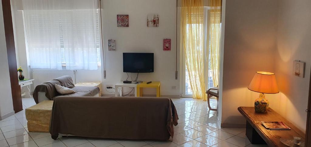 un soggiorno con un divano e una TV di A due passi dal mare a Santa Marinella