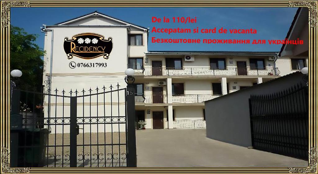 Una puerta delante de un edificio con un cartel. en Pension Recidency, en Oradea