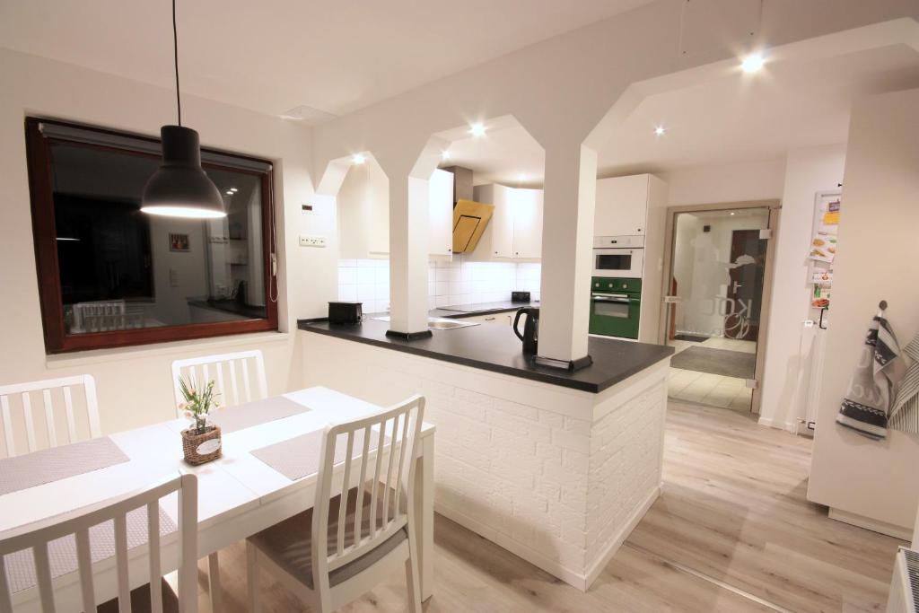 a kitchen and dining room with a table and chairs at WEIßE HÖHEN -Ferienhaus, Dibbersen bei Hamburg in Buchholz in der Nordheide
