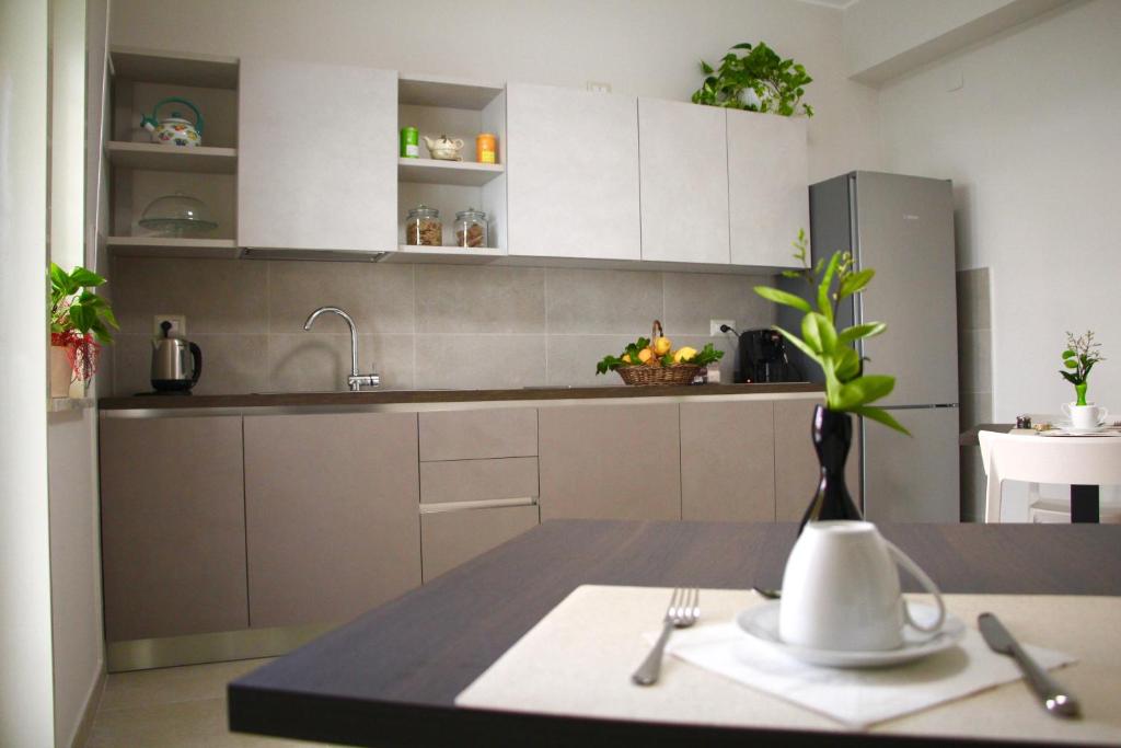 uma cozinha com armários brancos e uma mesa com um vaso em B&B Delle Serre em Messina