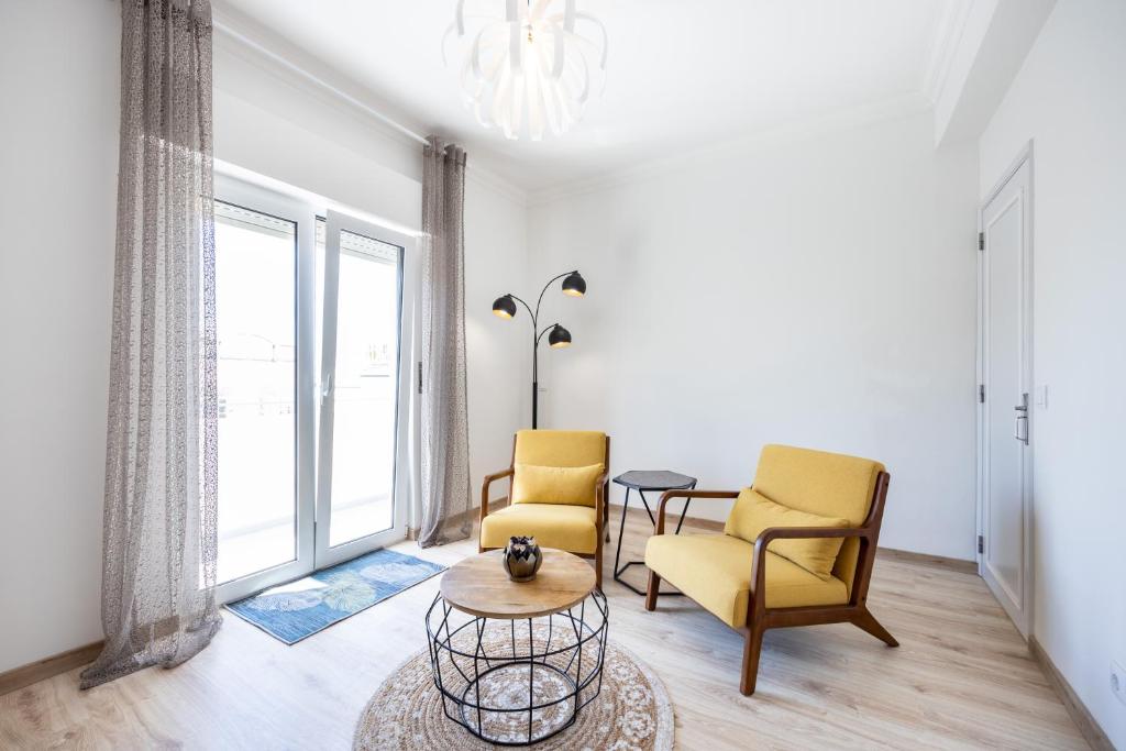 a living room with two chairs and a table at Casa do Mercado in Olhão